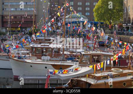 Londra, Regno Unito. 6 settembre 2025. Una festosa scena marina con barche in legno d'epoca adornate da bandiere colorate. La banchina è animata da visitatori, edifici a più piani e alberi sullo sfondo, che suggeriscono un evento pubblico per il patrimonio marittimo. St Katharine Docks Classic Boat Festival con oltre 60 barche classiche e d'epoca, tra cui le piccole navi di Dunkirk in mostra al pubblico. Penelope Barritt/Alamy Live News Foto Stock