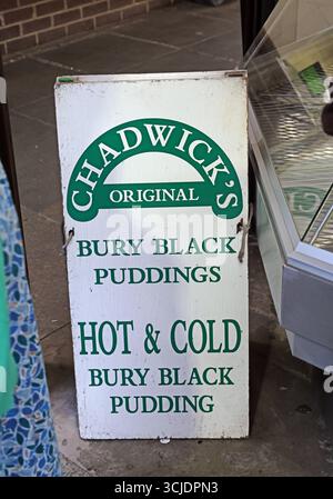 Insegna fuori dalla banchina di Chadwick che pubblicizza i budini originali Bury Black all'interno di Bury Market, Bury, Greater Manchester, Inghilterra, Regno Unito. Chadwick Foto Stock