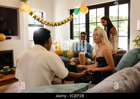 Festeggiamo il compleanno a casa, gli amici fanno regali e si divertono insieme Foto Stock
