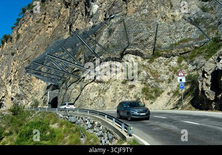 Auto che guidano sotto reti di sicurezza sulla strada a rischio di scosse Les Pontis, Val d'Anniviers, Vallese, Svizzera Foto Stock