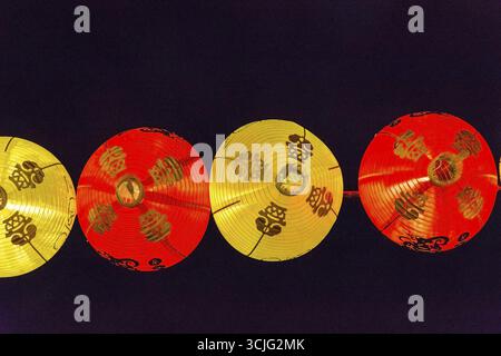 Vista illuminata rotonda tradizionale garland appeso contro del cielo notturno. China town, Singapore Foto Stock