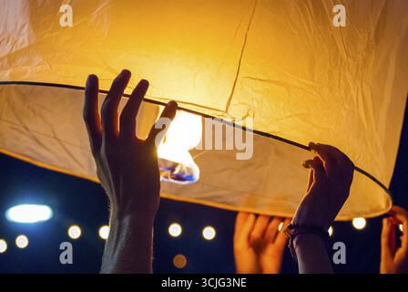 Il rilascio di una luce di lanterna durante il Loy Krathong festival in Chiang Mai, chiudere l immagine di mani Foto Stock