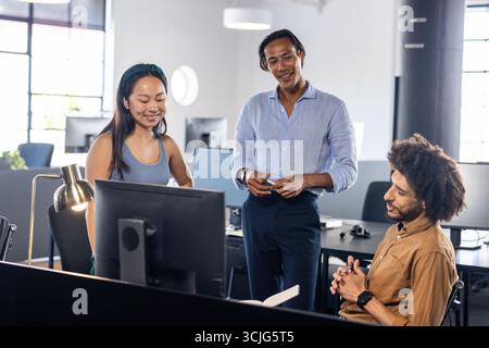 Team aziendale diversificato che collaborano al progetto in un moderno ambiente di lavoro Foto Stock