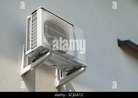 unità esterna di un sistema di aria condizionata diviso montata sulla parete esterna di un edificio per il raffreddamento del clima interno nei paesi caldi per l'hvac Foto Stock