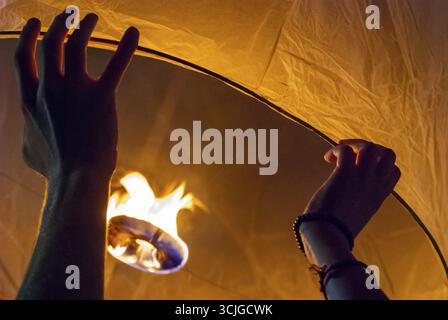 Il rilascio di una luce di lanterna durante il Loy Krathong festival in Chiang Mai, chiudere l immagine di mani Foto Stock