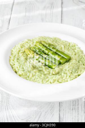 Risotto cremoso con punte di asparagi verdi, guarnito e presentato splendidamente Foto Stock