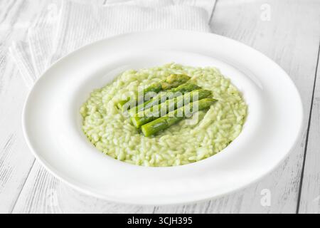 Risotto cremoso con punte di asparagi verdi, guarnito e presentato splendidamente Foto Stock