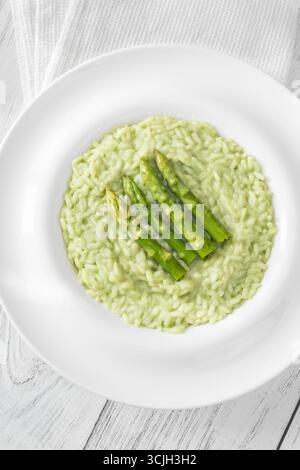 Risotto cremoso con punte di asparagi verdi, guarnito e presentato splendidamente Foto Stock