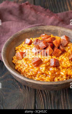 Risotto sostanzioso con chorizo, pomodori maturi ed erbe aromatiche servito in un rustico recipiente in ceramica Foto Stock
