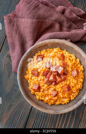 Risotto sostanzioso con chorizo, pomodori maturi ed erbe aromatiche servito in un rustico recipiente in ceramica Foto Stock