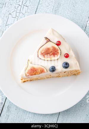 Torta al formaggio spalmabile con spicchi di fichi ribes mirtilli servita con piatto bianco Foto Stock