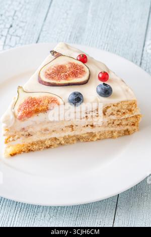 Torta al formaggio spalmabile con spicchi di fichi ribes mirtilli servita con piatto bianco Foto Stock