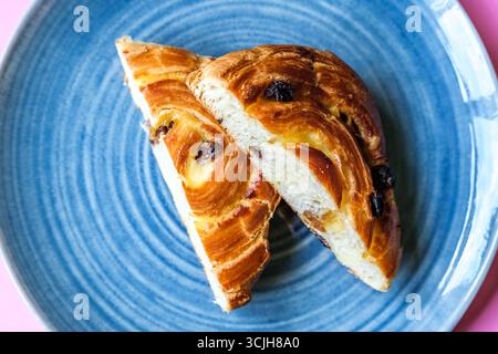 Londra Regno Unito, 07 settembre 2025, Single Pain Aux Raisin Cut in Half on A Plate Foto Stock