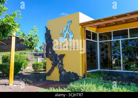 Puerto Ayora, isola di Santa Cruz, Galápagos, Ecuador - 2018: Esterno della stazione di ricerca Charles Darwin, con la sua iconica parete d'ingresso gialla Foto Stock