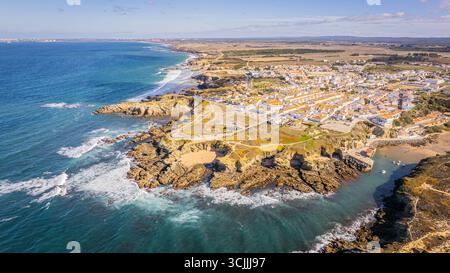 Vista aerea di Zambujeira do Mar, città costiera portoghese con scogliere rocciose, oceano Atlantico blu e case bianche, foto aerea panoramica del viaggio in Europa Foto Stock