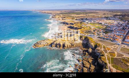 Zambujeira do Mar Portogallo panorama aereo con scogliere costiere onde oceaniche e villaggio sulla riva splendida vista del paesaggio costiero con droni Foto Stock