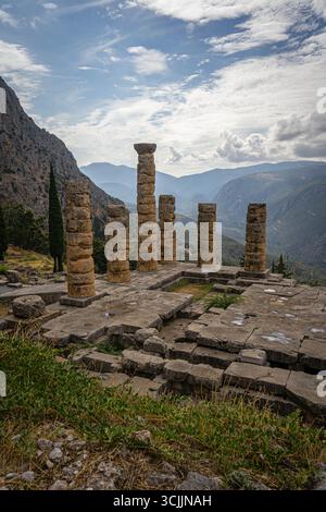Sito archeologico di Delfi in Grecia con rovine storiche del tempio di Apollo e vista panoramica delle montagne e della valle circostanti Foto Stock