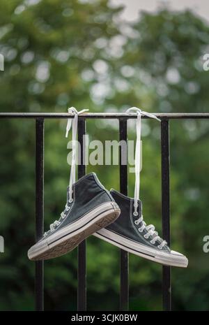 Scarpe da ginnastica Black All Stars Converse "Chuck Taylor" appese su un binario per balconi, Regno Unito Foto Stock