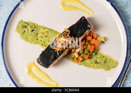 Filetto di salmone alla griglia servito con verdure e contorno gourmet Foto Stock