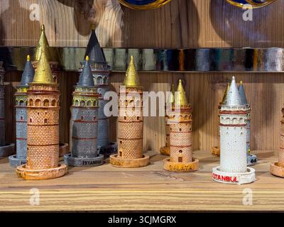 Souvenir in miniatura della Torre Galata di Istanbul disposti su scaffali in legno nel negozio di Istanbul. Patrimonio architettonico, simbolo e identità culturale Foto Stock