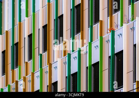 Facciata colorata dell'ufficio con pannelli verticali verdi e gialli che aggiungono ritmo, contrasto e vivacità architettonica. Foto Stock