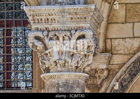 Dettagli ravvicinati delle sculture in arenaria sulla sommità delle colonne esterne del Palazzo del Rettore, sculture in stile gotico, Dubrovnik, Croazia Foto Stock