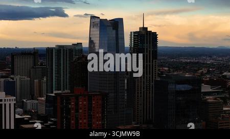 Vista aerea dei grattacieli che piangono il cielo crepuscolo, le loro facciate di vetro riflettono la luce che svanisce sopra il vivace paesaggio urbano di Denver, Denver, Colorado, Stati Uniti. Foto Stock