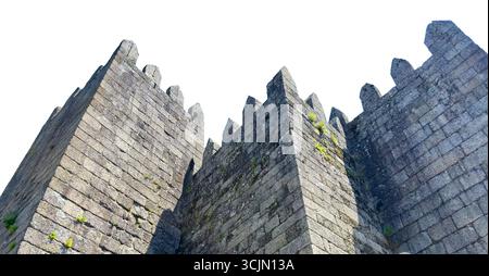 Mura medievali della fortezza del castello di Guimaraes in Portogallo, isolate su sfondo bianco. Le torri di pietra con merlature merlate mostrano lo storico gra Foto Stock