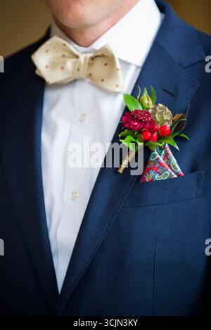 Sposo in tuta blu con cravatta e boutonnière floreale Foto Stock