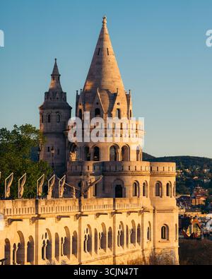 Vista del Bastione dei pescatori, una fortezza fiabesca di pietra pallida, si erge contro il sereno cielo blu, gettando lunghe ombre nella calda luce del pomeriggio, Budapest, Ungheria. Foto Stock
