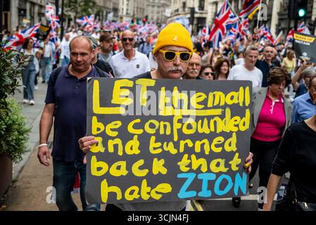 Uomo con cartellone sionista, marcia contro l'antisemitismo - decine di migliaia di persone marciano nel centro di Londra opponendosi all'antisemitismo e alla guerra in rapida crescita Foto Stock