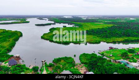 Vista aerea di un fiume tortuoso che attraversa lussureggianti paesaggi verdi, con sacche di insediamenti lungo le sue rive, Nkpogu, Port Harcourt, Rivers State, Nigeria. Foto Stock