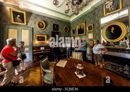 Tour guidato della George Sand House a Nohant. Ecco il salone con molti ritratti di George Sand e della sua famiglia. Tra questi, sopra il camino, si trova il famoso ritratto dipinto da Auguste Charpentier nel 1838. La tenuta di campagna può essere visitata solo come parte di un tour guidato. Place Sainte-Anne, Nohant-Vic, Centre-Val de Loire, Francia Foto Stock