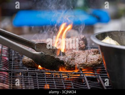 Cuocere alla griglia il kofta di agnello arabo al caldo del carbone. Gustosi bastoncini di kofta arabi su una griglia a carbone calda. Kebab kofta di agnello cotti sopra le fiamme calde del carbone Foto Stock
