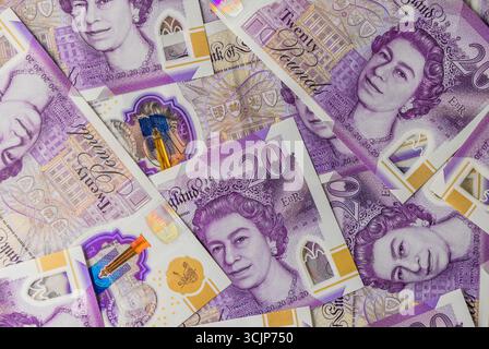 Una pila di banconote inglesi da 20 sterline, concetto di finanza, risparmio, investimenti e background aziendale. Foto Stock