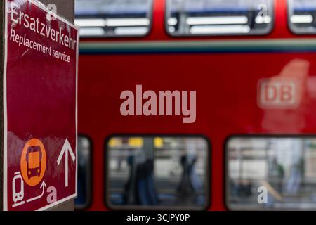 Ersatzverkehr am Bahnhof Hinweisschild zum Schienenersatzverkehr 08.09.25, Selters: Symbolfoto, Illustrationsbild, Symbolbild, Illustrationsfoto, Alltagsszene Ein Schild am Bahnsteig weist auf den Ersatzverkehr Hin. Der Hinweis in Deutsch und Englisch informiert Fahrgäste über den Schienenersatzverkehr servizio di sostituzione mit Bussen. Im Hintergrund ist unscharf ein roter Doppelstockzug der Deutschen Bahn zu sehen. Limburg Hessen Deutschland *** servizio di sostituzione alla stazione cartello per il servizio di sostituzione della ferrovia 08 09 25, foto simbolo Selter, foto illustrazione, immagine simbolo, foto illustrazione Foto Stock