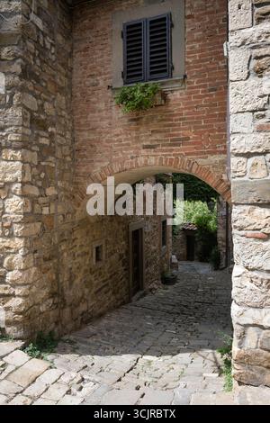 Stretta strada acciottolata nel villaggio fortificato di Montefioralle in Toscana, Italia Foto Stock