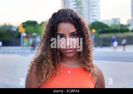 Giovane donna nera seria all'aperto in un ambiente urbano. Foto Stock