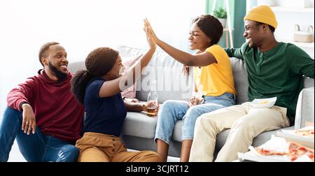 Due giovani coppie nere che si divertono insieme a casa Foto Stock