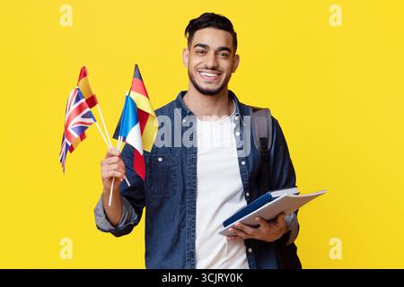 Studente medio-orientale positivo che mostra bandiere di diversi paesi Foto Stock