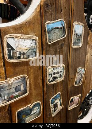 Tarnopil, Ucraina - 10 agosto 2025: Superficie in legno con cornici fotografiche che mostrano stili architettonici catturati in composizioni uniche Foto Stock