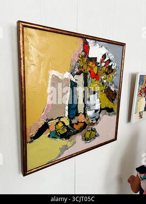 Tarnopil, Ucraina - 10 agosto 2025: Opere d'arte astratte moderne con pennellate vivaci e tonalità calde, incorniciate in oro. Foto Stock