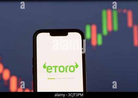 Apertura dell'app di investimento eToro sullo schermo dello smartphone Foto Stock