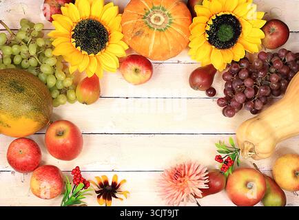 Contesto del Ringraziamento, concetto di raccolta, composizione autunnale con frutti, bacche naturali, cocomeri, meloni, frumento, mele, fiori e orecchie di whea Foto Stock