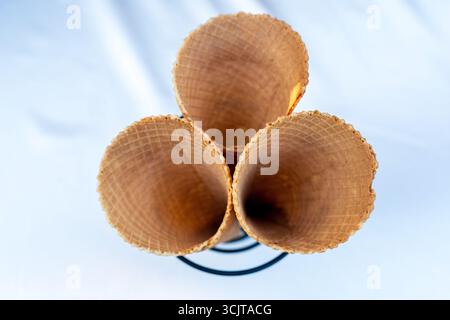 Tre coni di gelato marrone vuoti su White Table Foto Stock
