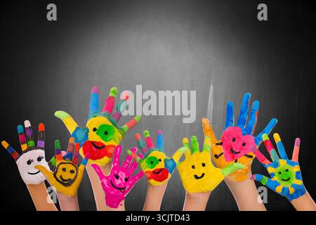 mani per bambini colorate con facce divertenti Foto Stock