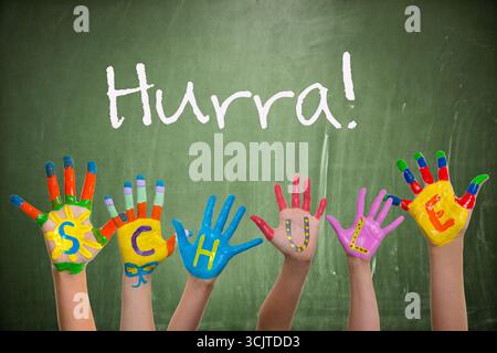 Sei mani colorate con la parola "Schule, School" davanti a una lavagna nera con la parola "Hurra, Hurrah!" Foto Stock
