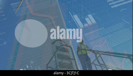 Tecnico che indossa il giubbotto di sicurezza e la scala di arrampicata del casco sulla torre del parco eolico, con tabelle dati Foto Stock