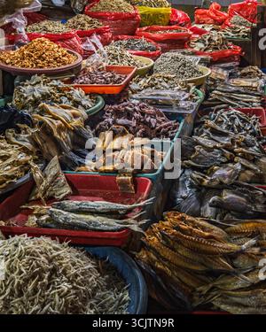 Balikpapan, Indonesia - 22 agosto 2025. Pesci secchi assortiti, acciughe e prodotti a base di pesce esposti in cesti e vassoi in una tradizionale Indonesia Foto Stock