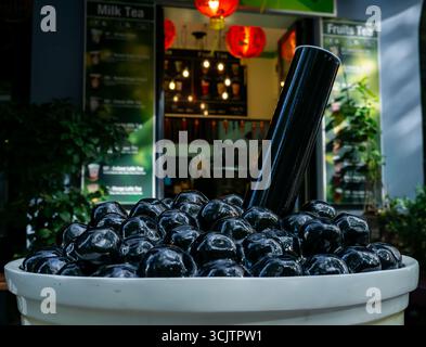 Primo piano di una gigantesca scultura di una tazza di tè a bolle all'esterno di un moderno negozio di tè a Berlino Prenzlauer Berg in una giornata di sole. Foto Stock